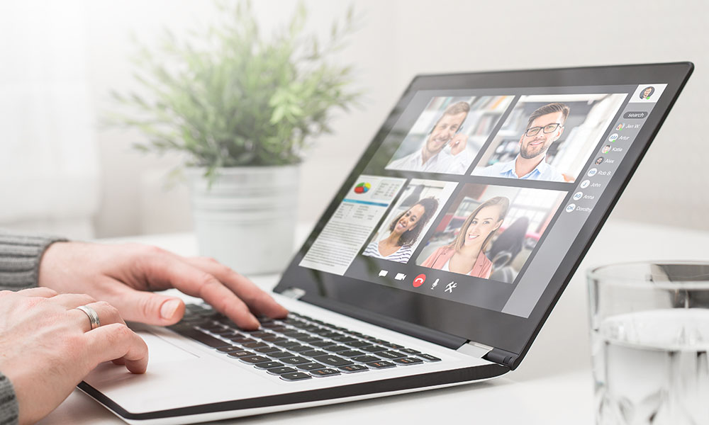 Ordenador con una vídeollamada en el que una persona dirige un equipo de trabajo en un entorno virtual
