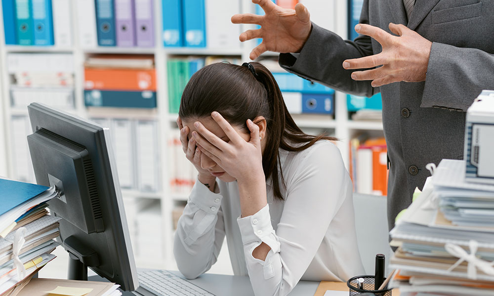 Mujer sufriendo acoso psicológico o mobbing en el entorno laboral